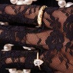 Glitz Ring and Adeline pear-cut ring in gold, worn over black lace gloves with pearls